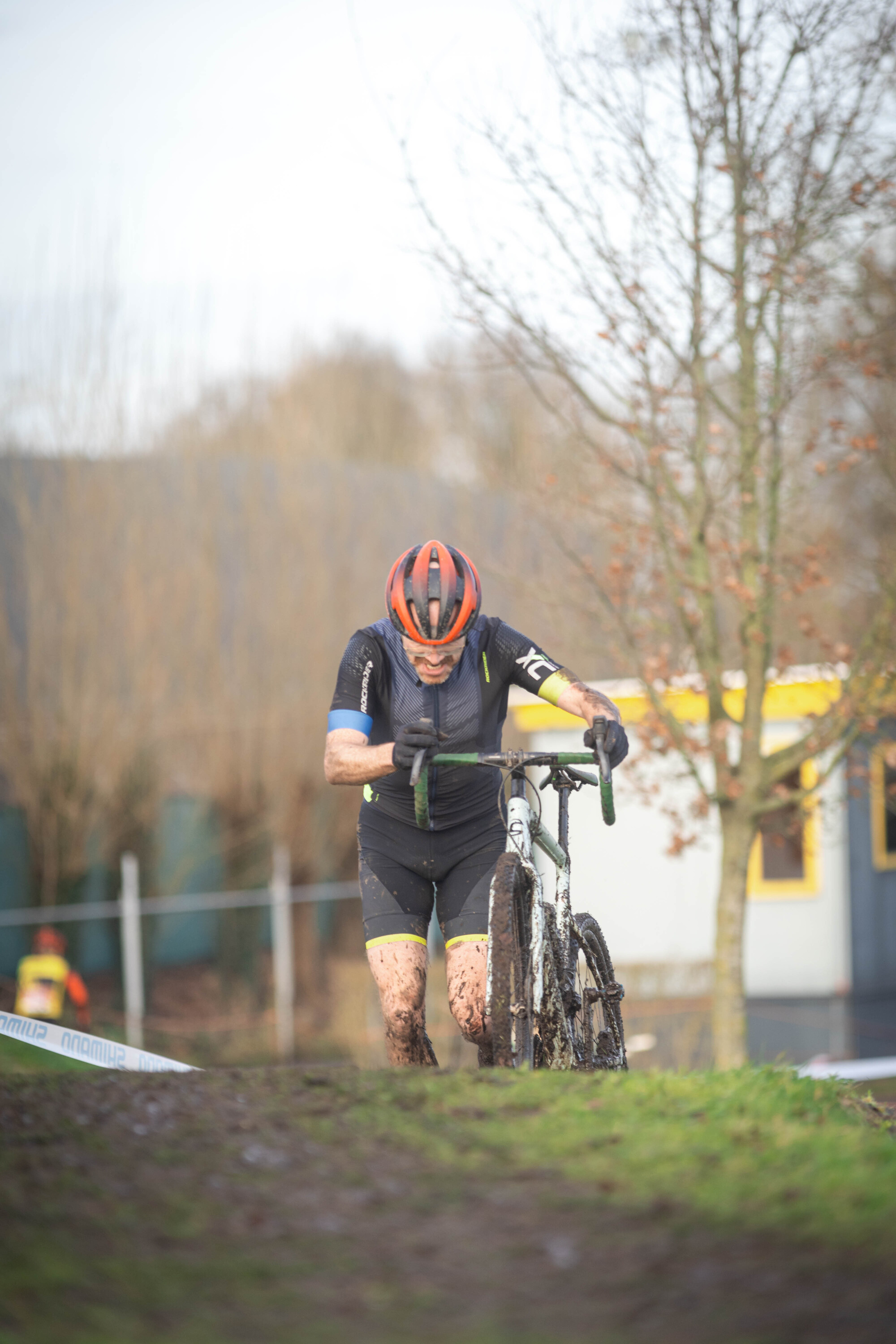 A man in a red helmet and black shirt riding his bike with the number 2023 on his arm.