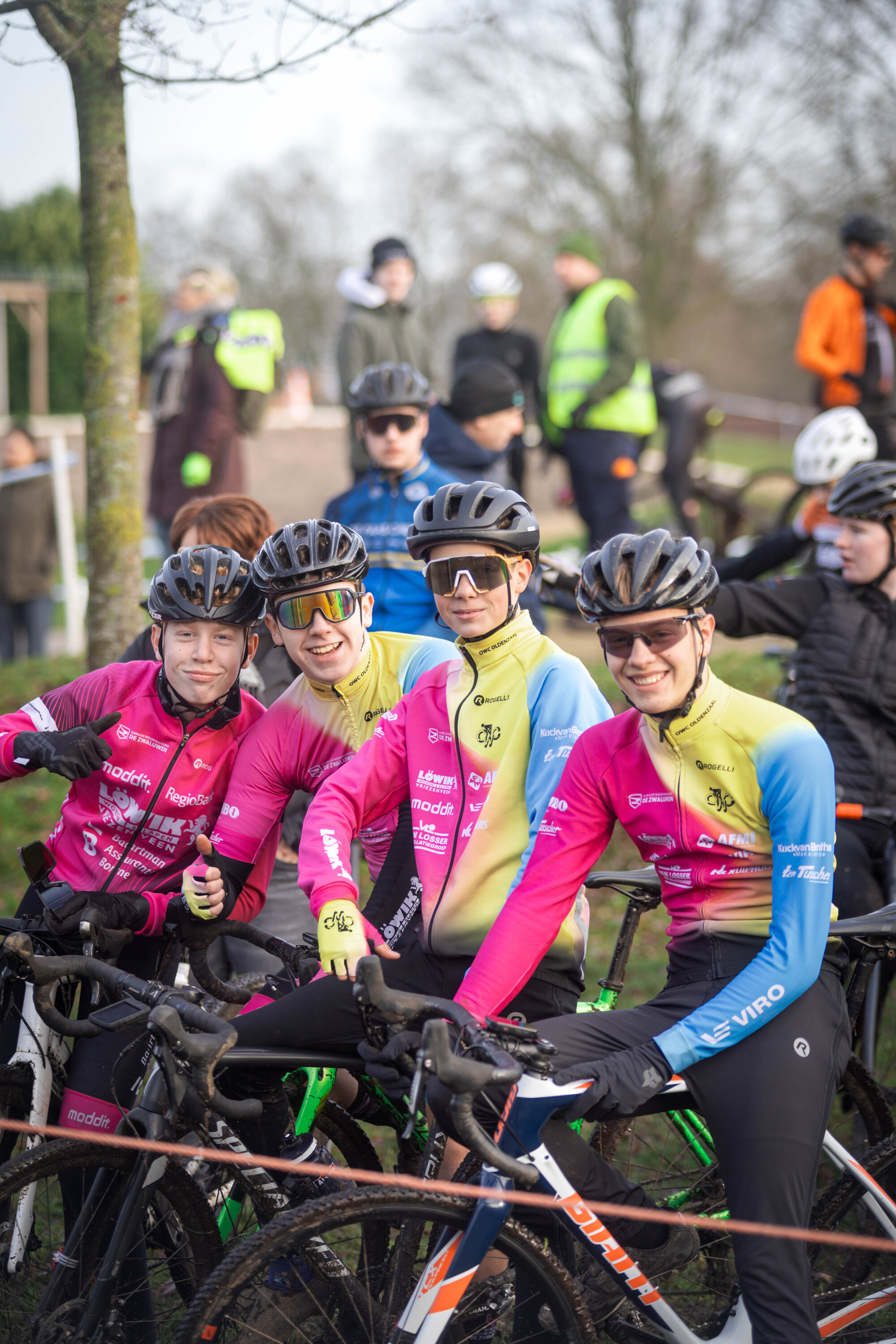 Four people sitting on bikes wearing cycling gear, one of them has the word "Masters" written on his uniform.