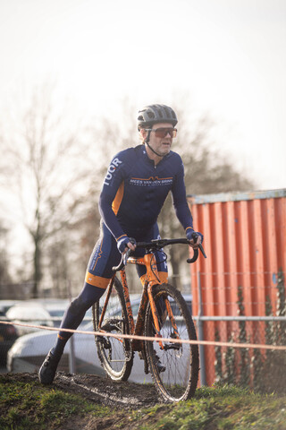 A man riding a bike with the word cyclocross on his chest.