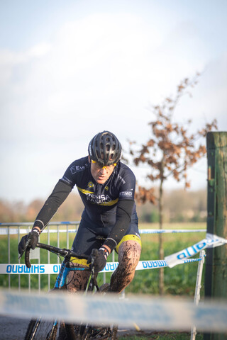 A man is riding a bike in the Master's Cyclocross competition in 2023.