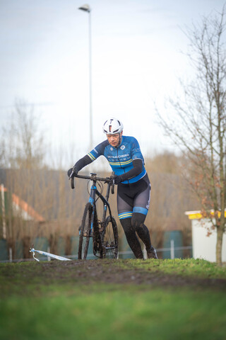 A person in a blue and black jacket is riding a bicycle.