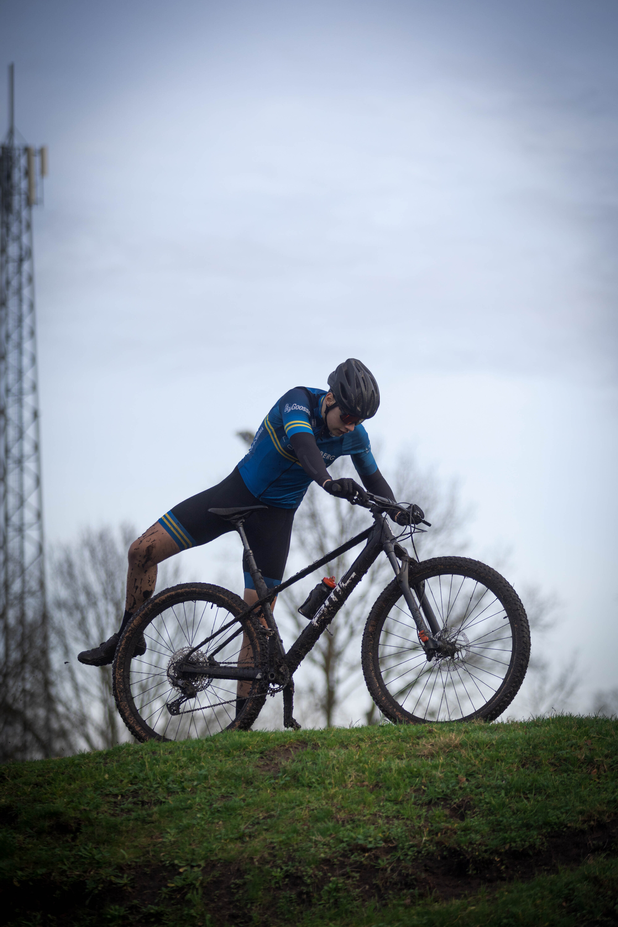 a person on a bike with a blue shirt that has the word cyclocross on it.