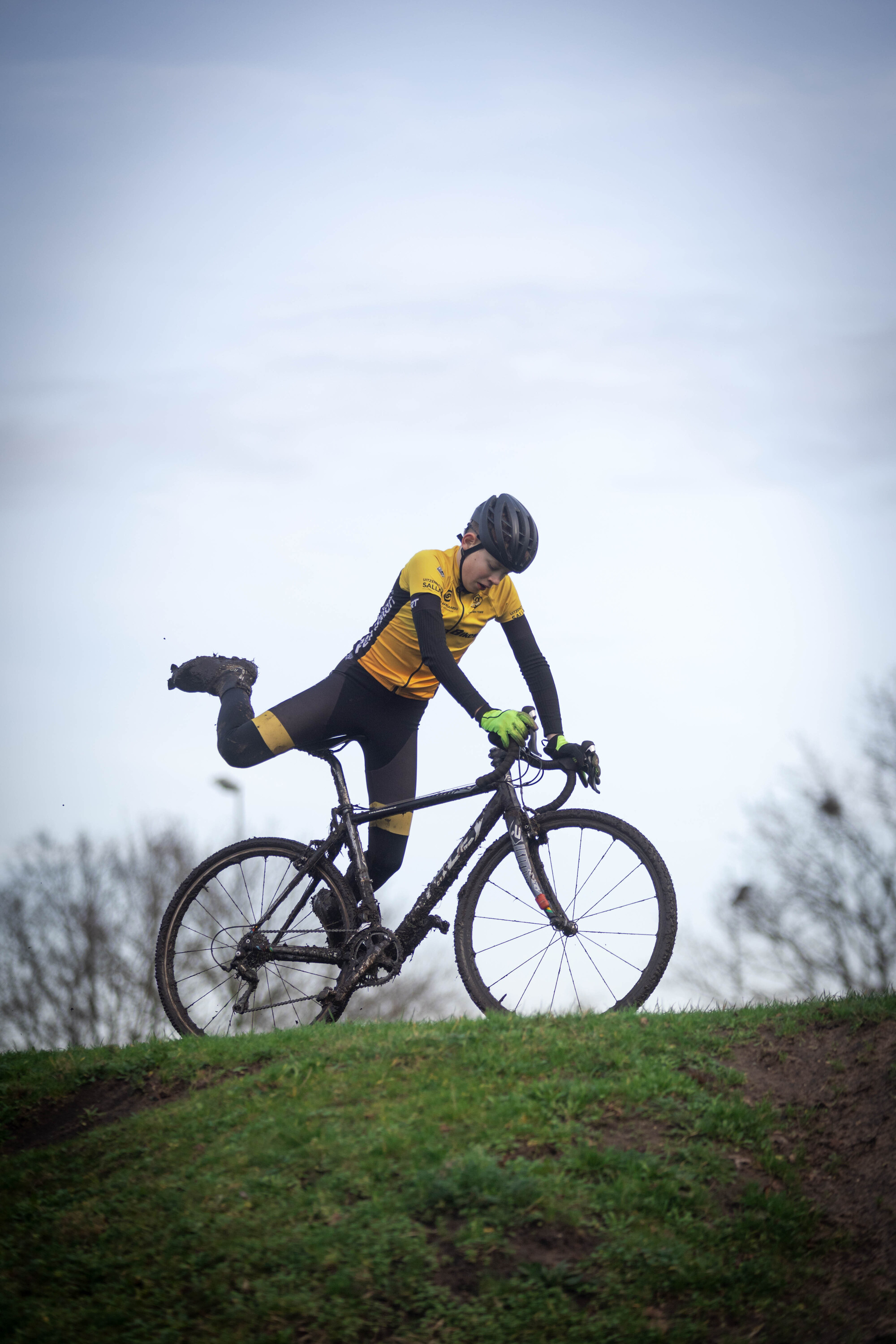 The cyclist is wearing a yellow shirt and a black helmet.