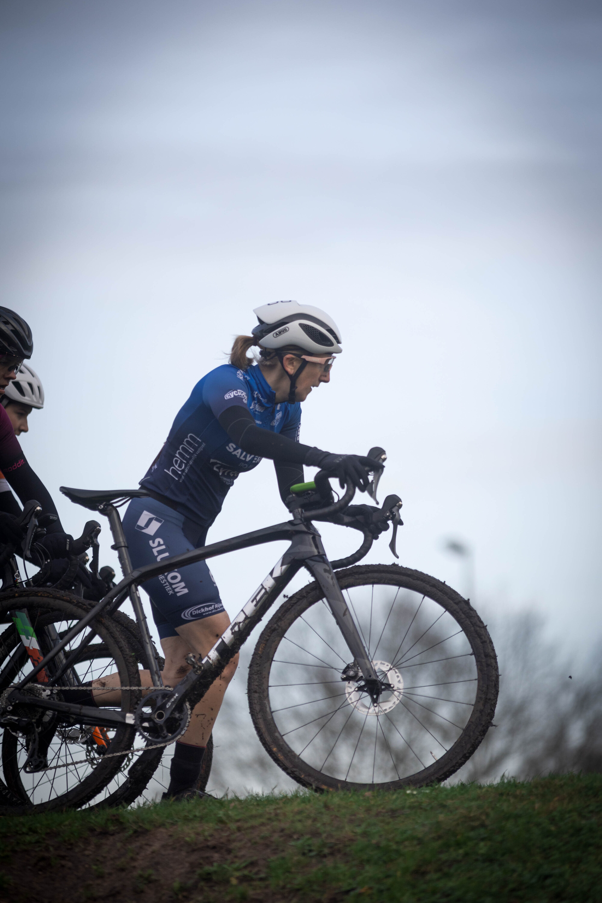 A cyclist is riding a black bike with a blue shirt and helmet.