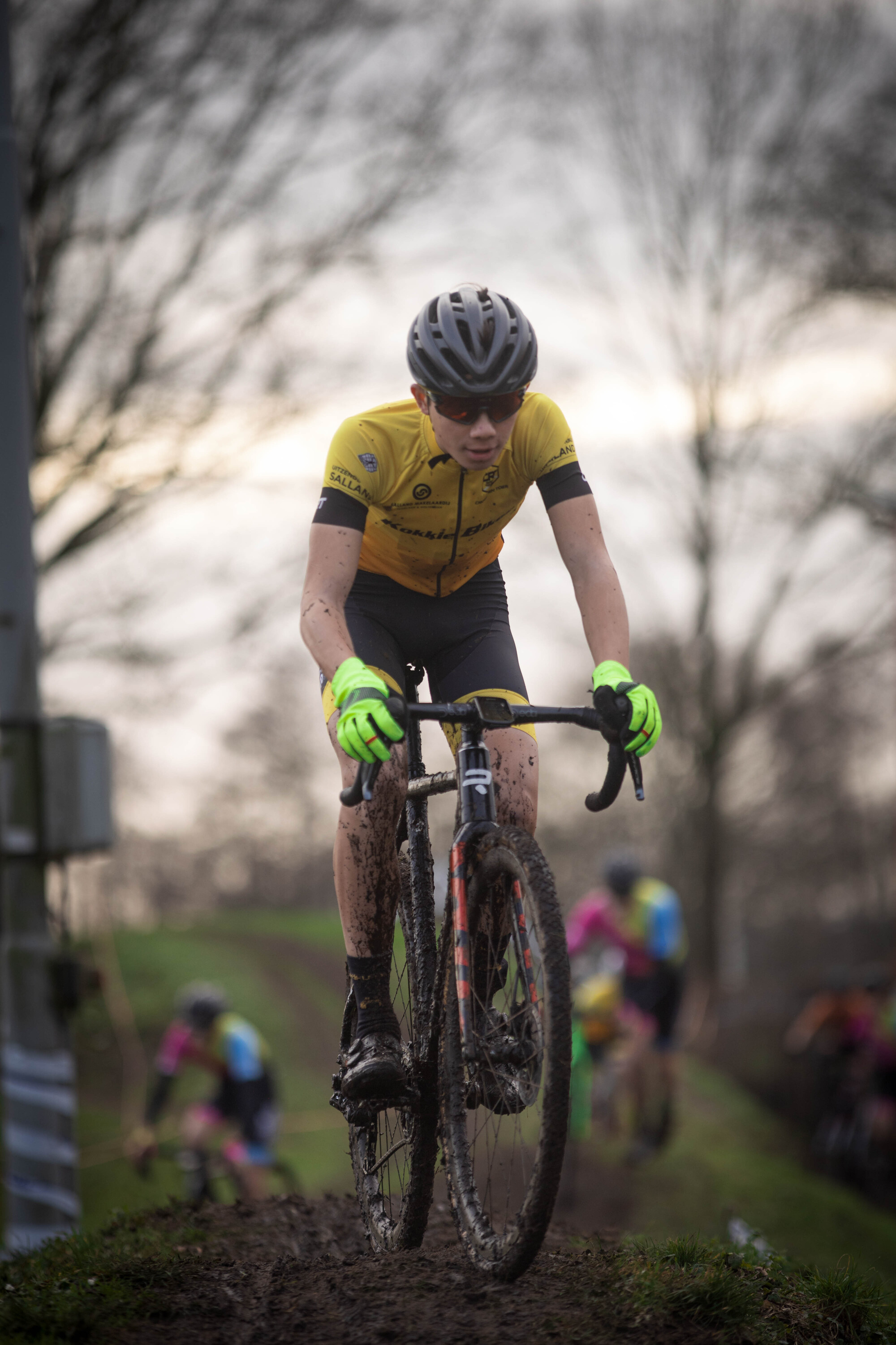 A man is riding a bike down the track at a cyclocross event.