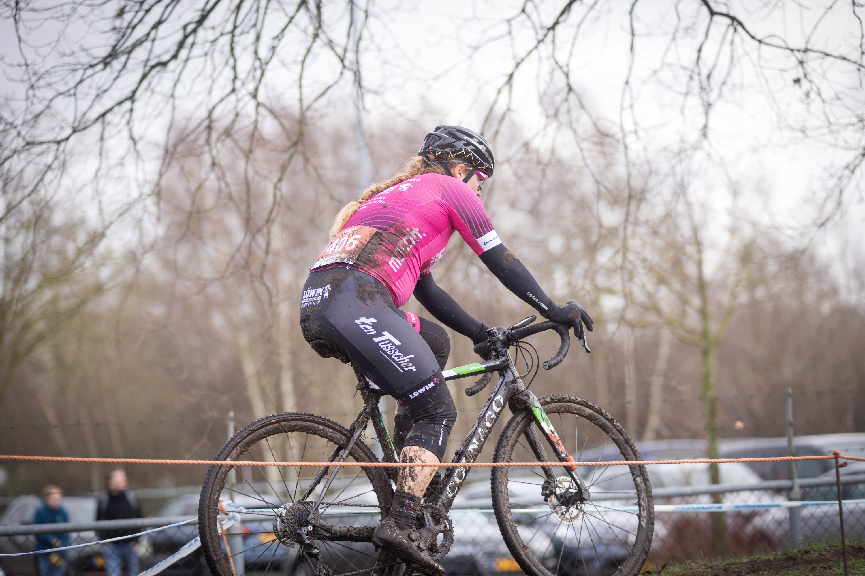 A woman riding a bicycle with the number 2023 on her back.