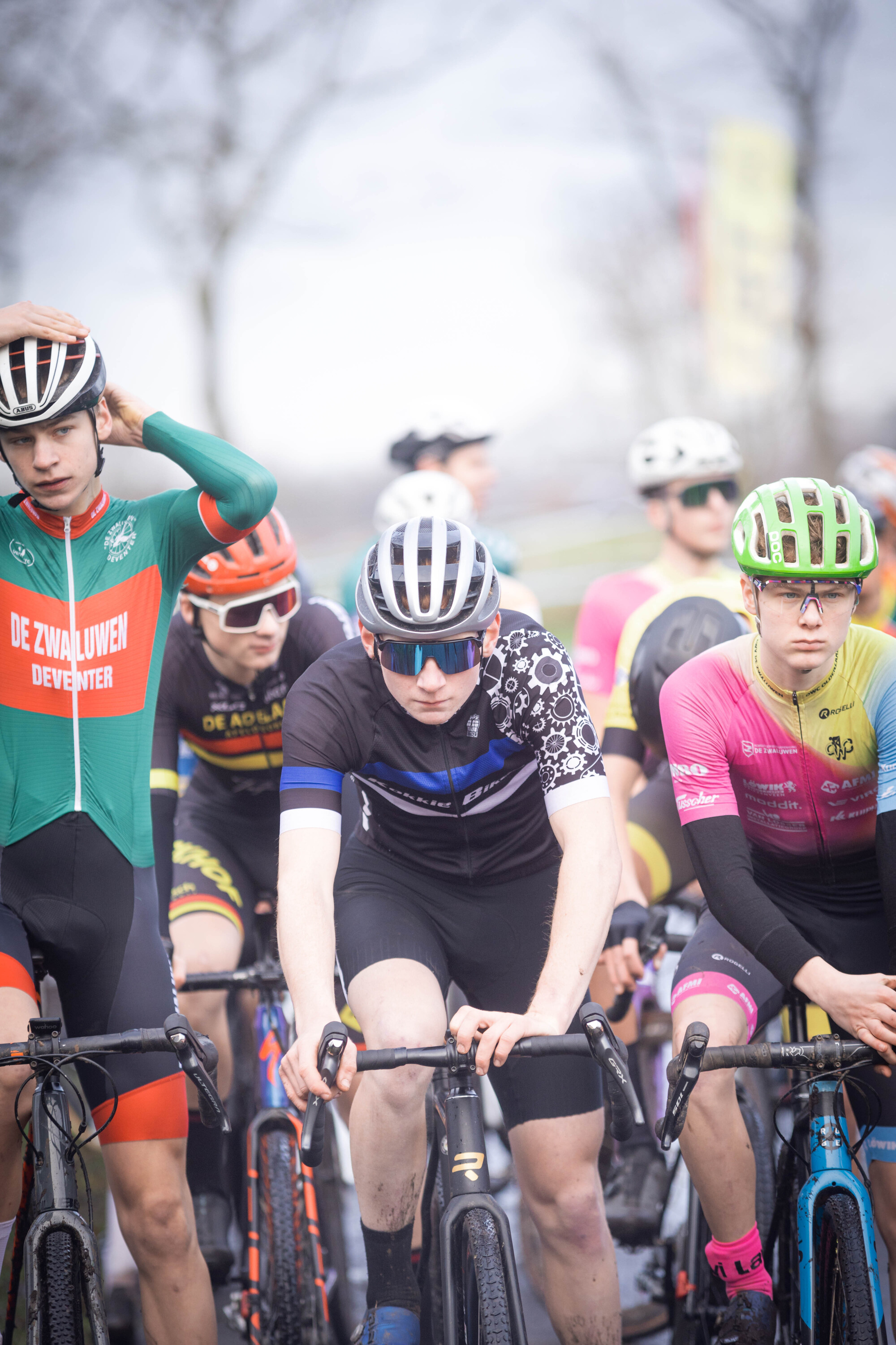 A group of cyclists wearing safety gear like helmets are participating in a cycling race.