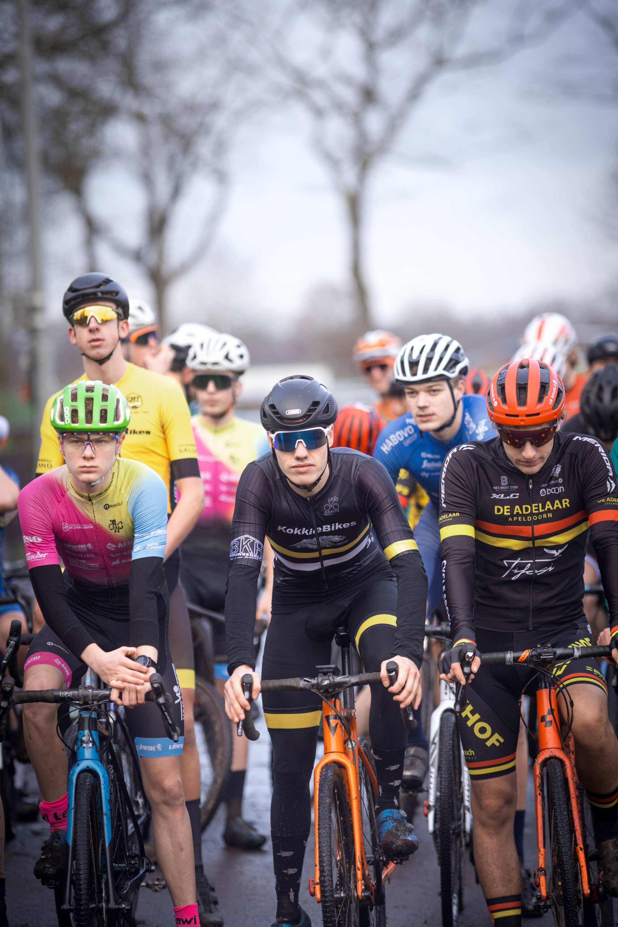 A group of cyclists wear helmets with the letters "JU", "EL", and "AM" on them.