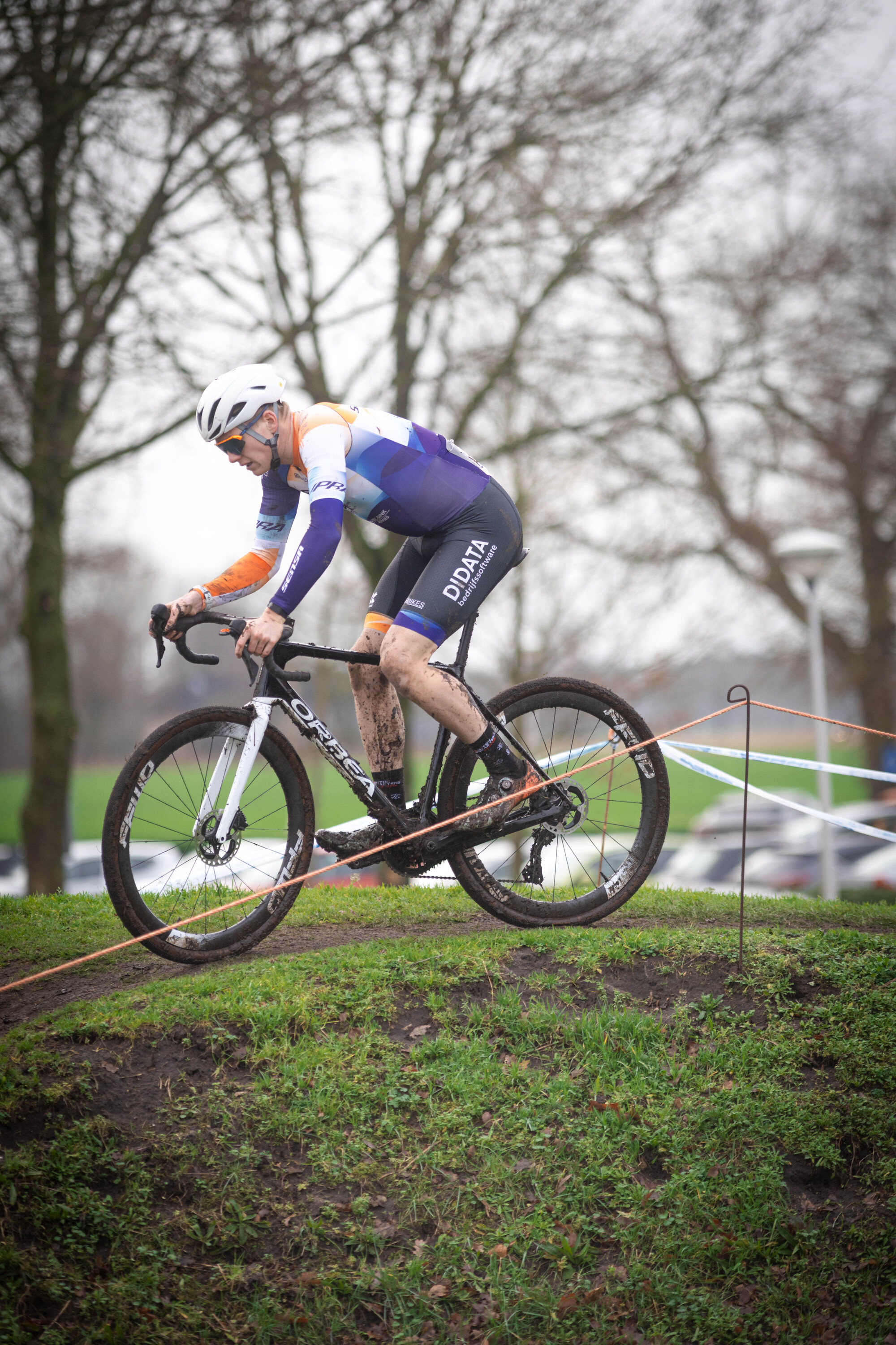 A person on a bicycle with the letters JU/EL/BE/AM on their jersey.