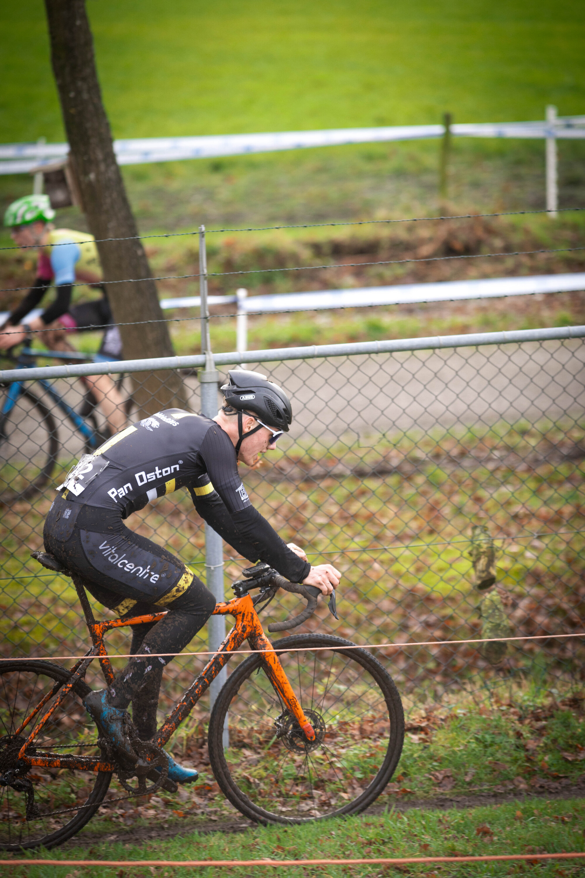 A cyclist wearing a black jersey with the words "JU/EL/BE/AM" in white letters.