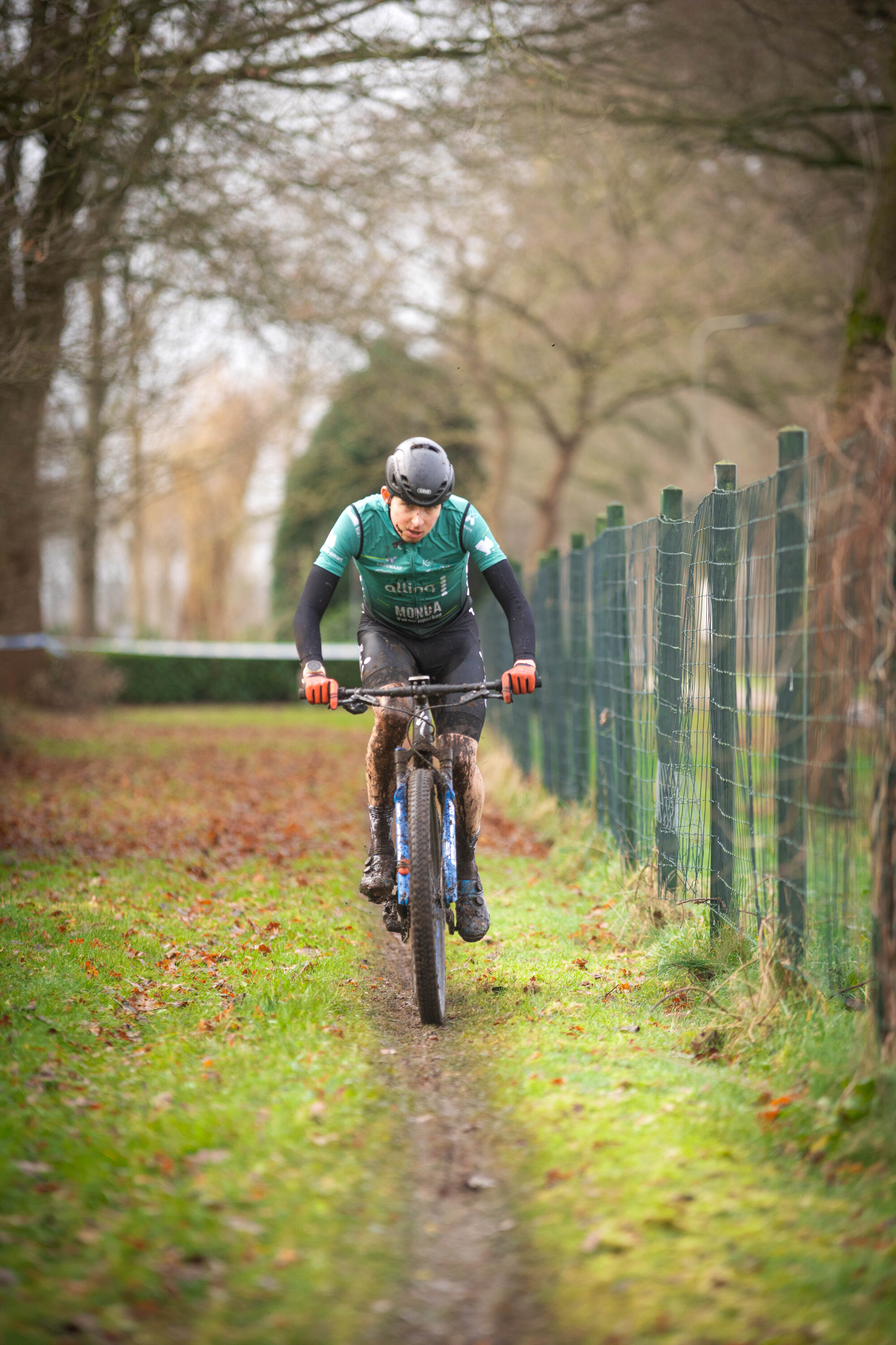 A person riding a blue and black bike wearing a green shirt.