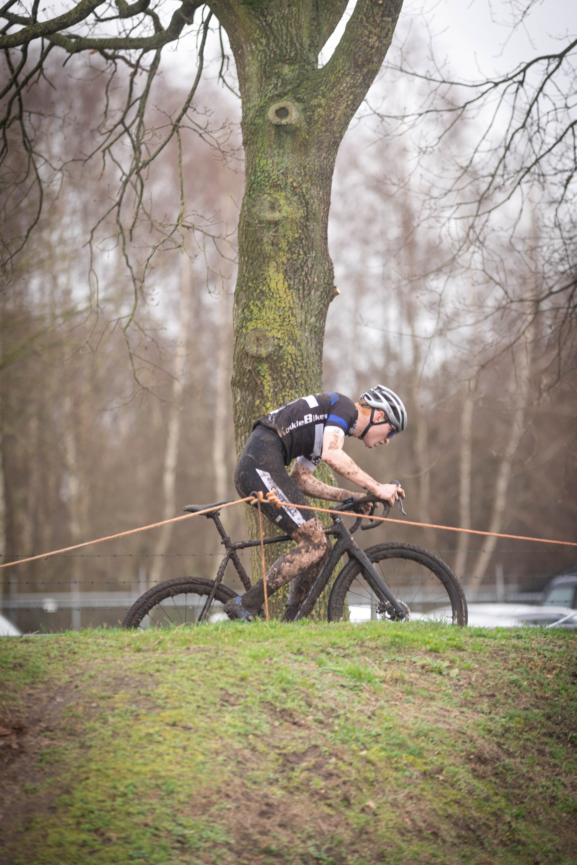 A man in a number 42 jersey and black pants rides a mountain bike.