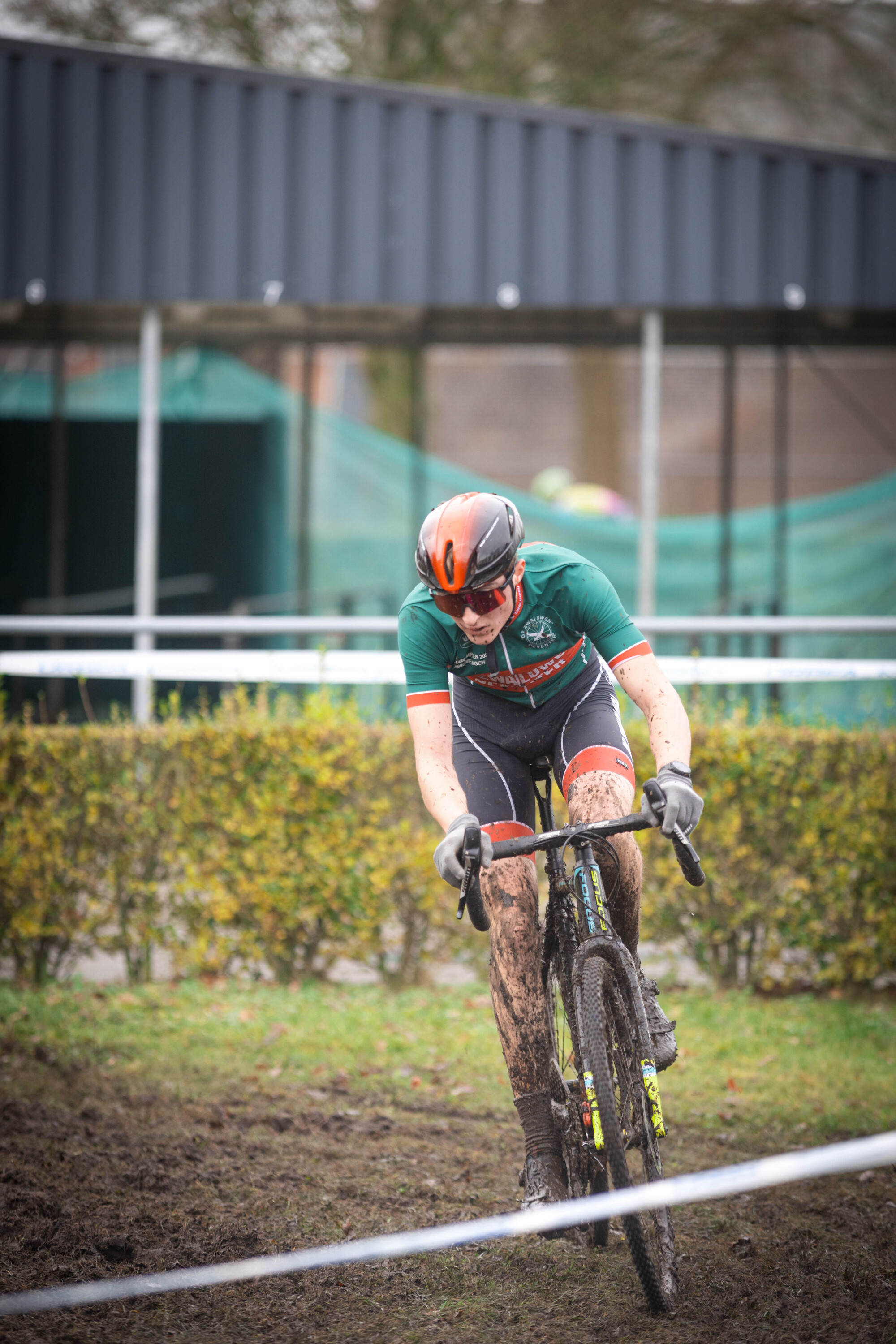 a person on a bicycle that is wearing an orange helmet.