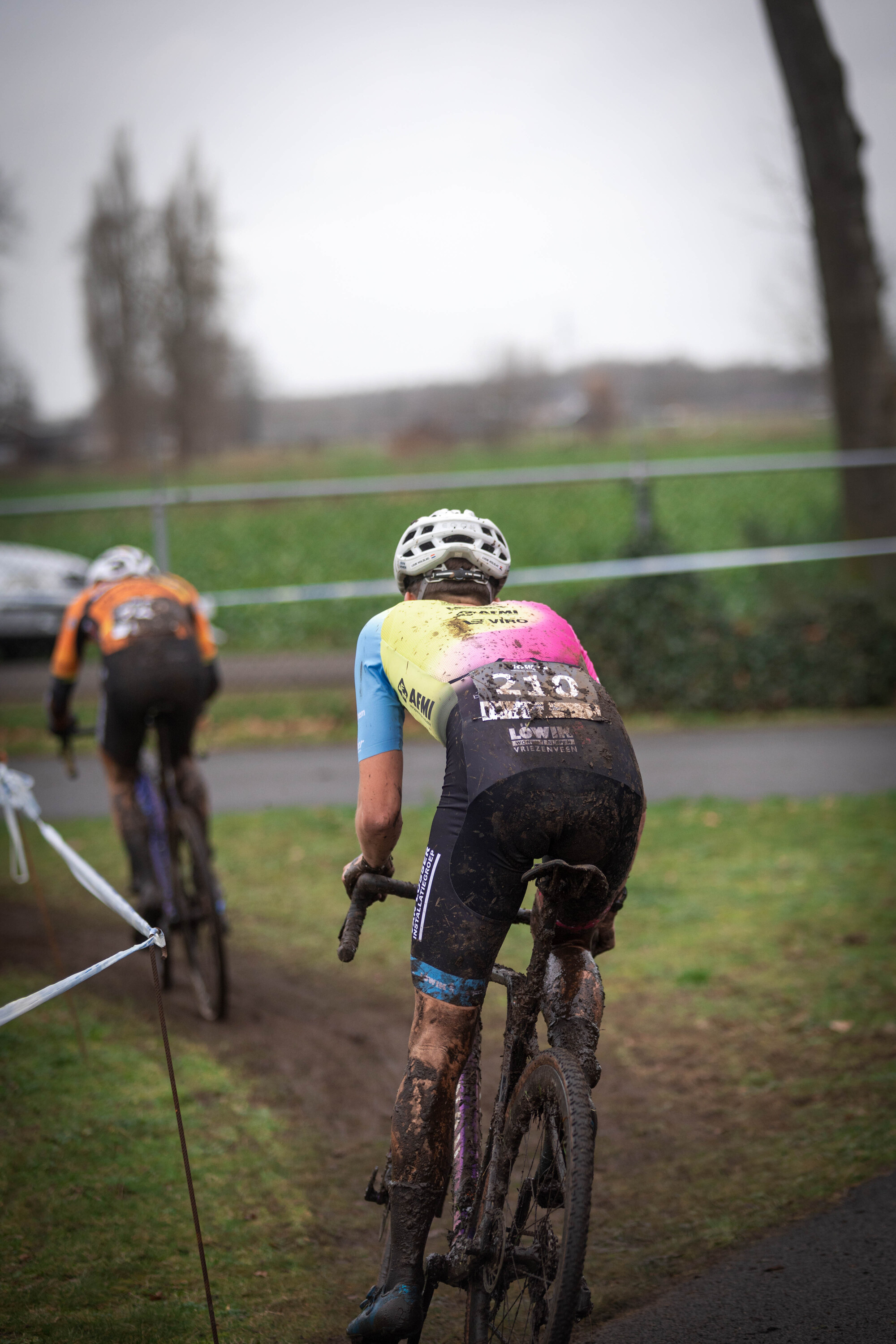 Two cyclists compete in a thrilling cyclocross race.