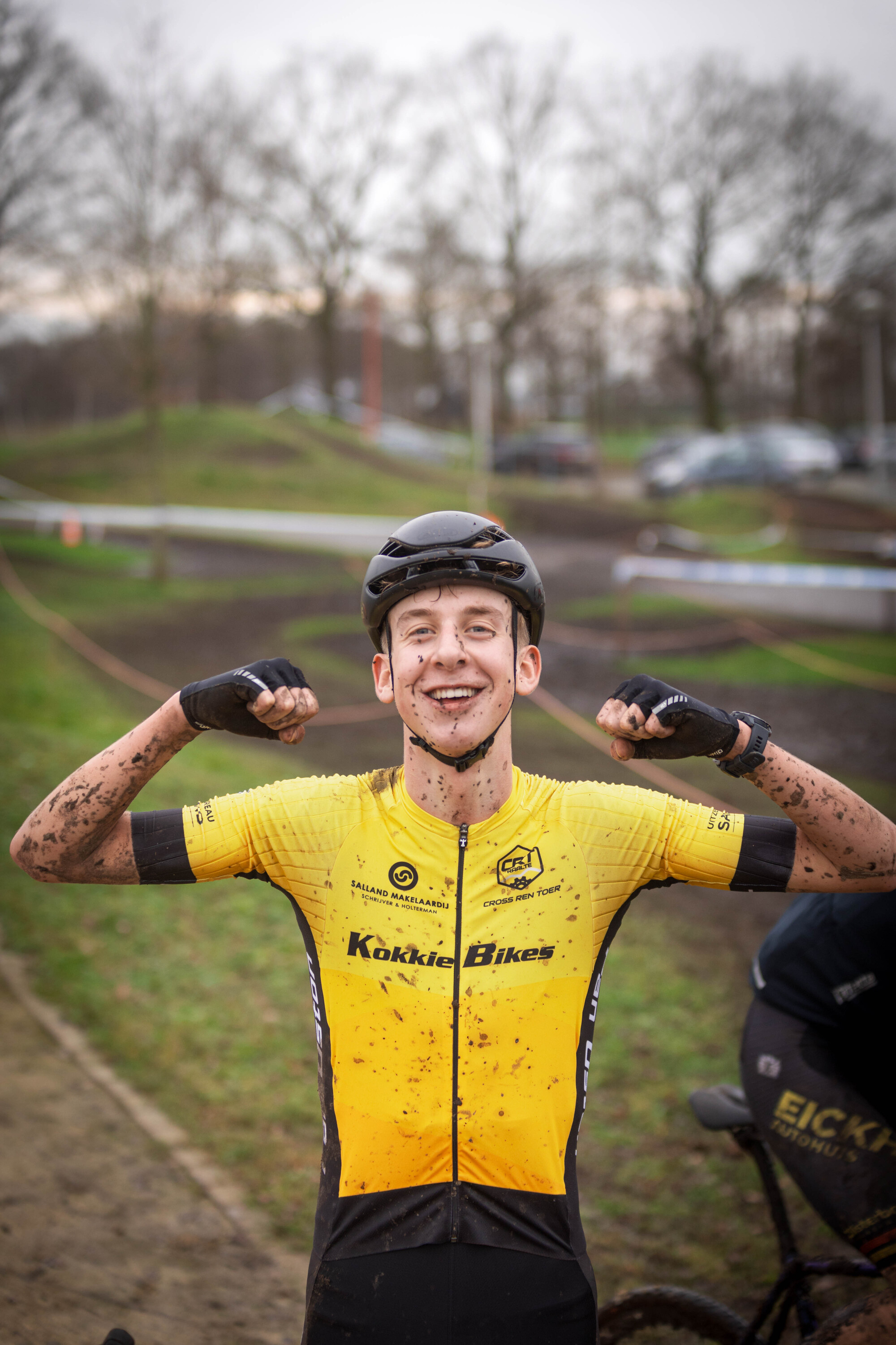 The man in the yellow shirt is the winner of this cyclocross race.