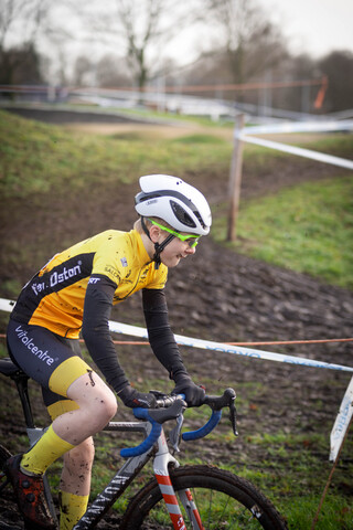 A person wearing a yellow shirt and white helmet is riding a bike.