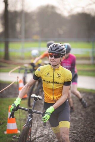 A cyclist in a neon yellow shirt with the words "Ju/El/Ba" written on it.