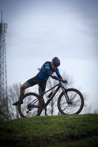 a person on a bike with a blue shirt that has the word cyclocross on it.