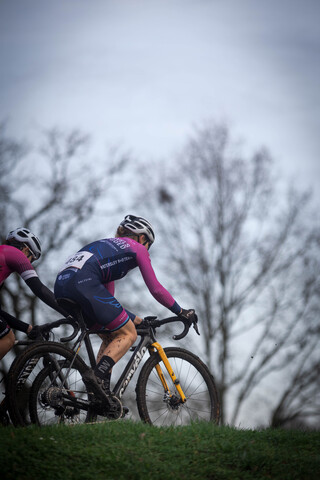 Two cyclists racing each other in a cyclocross event.