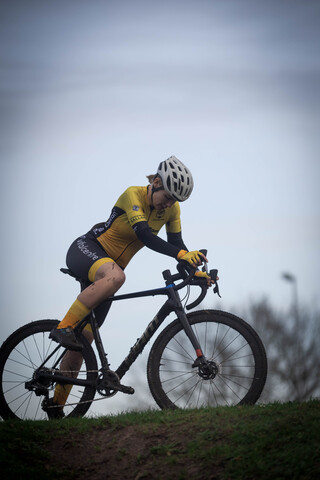 A person riding a bicycle in yellow and black attire.