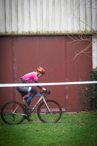 A woman on a bicycle wearing pink and purple clothing.