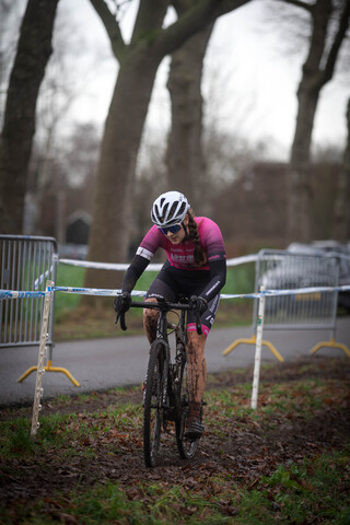 A cyclist is on a course with a pink and black jersey.