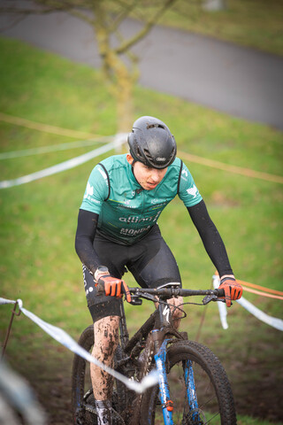 a person riding a bike, with the word Cyclocross on their shirt.