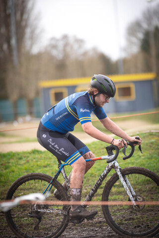 A man in a blue shirt and black helmet is riding his bike on the dirt. The words GWR Raalte are visible.