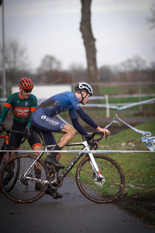 A man wearing a blue and white suit with the word "GOW" on it is riding his bike.