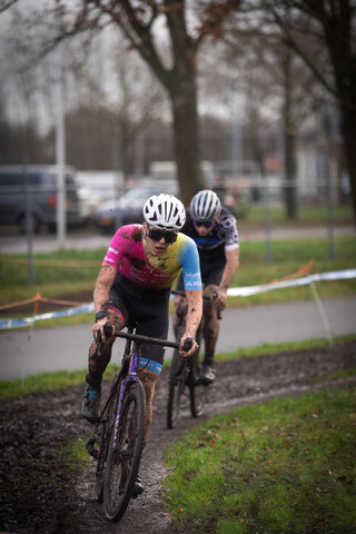 A cyclist in a pink jersey races with another cyclist.