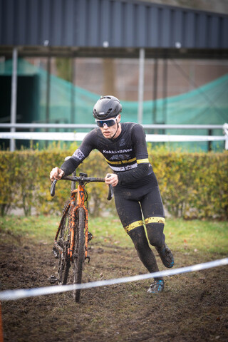 A cyclist with the words Cyclocross on his jersey is riding a bike through the mud.