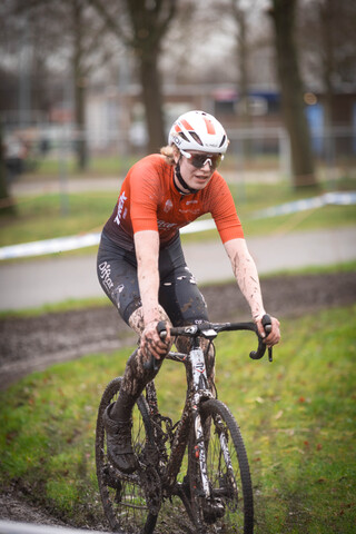 A cyclist riding a dirty bike with the number 5 on it.