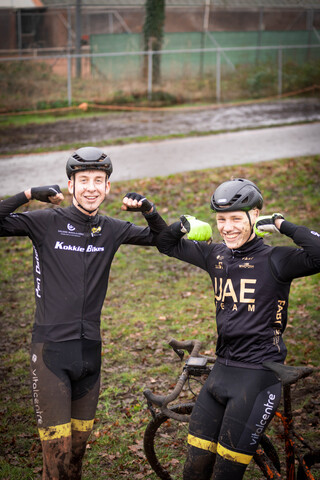 Two cyclists on a grassy field with the rider on the left wearing a black and yellow jersey that says "Energizer" on it.