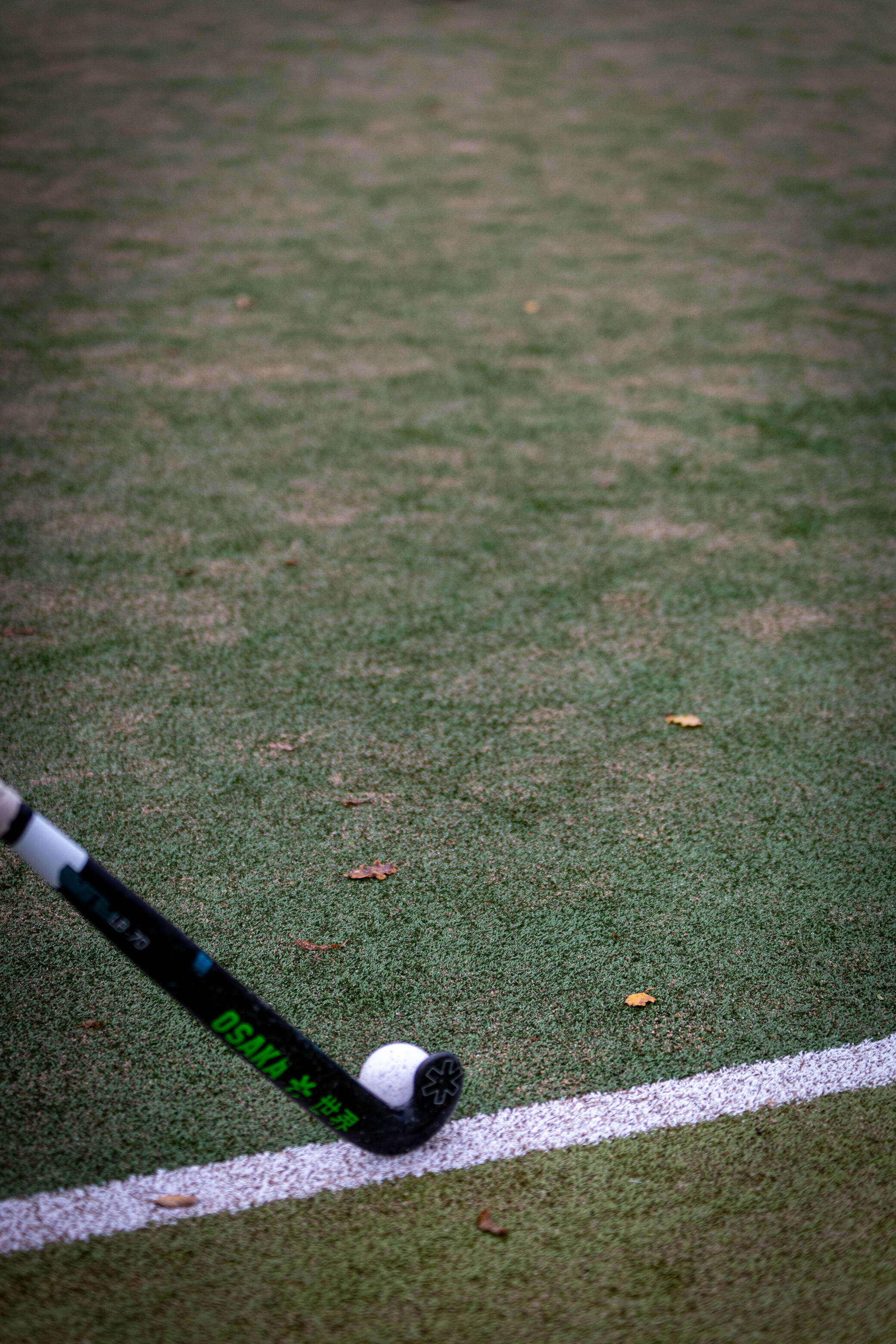 A hockey stick with a blue and white handle on top of the ground.