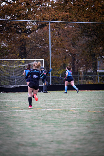 Three women are playing hockey, one of them is named SMHC 19-11.