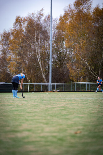 A man in a blue hockey uniform with number 5 on the back is wearing a mask.