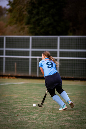 A woman in a blue hockey uniform is wearing the number 9.