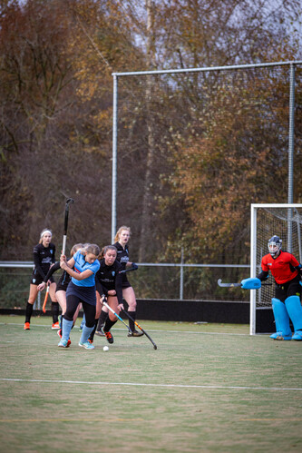 SMHC 19-11 2023 Hockey game. 5 players in black jerseys are playing. The goalie in the blue jersey is watching.