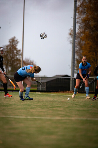 A group of female hockey players are on a field, ready to play.