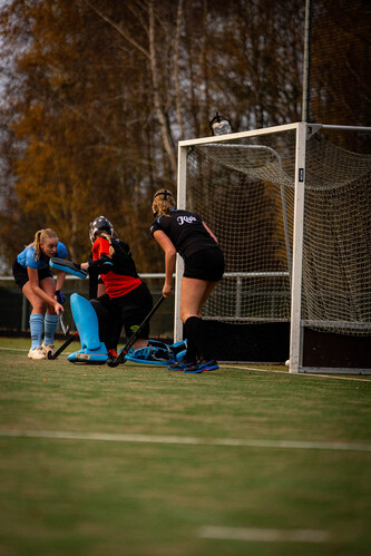 A group of women playing hockey, one with a sign on her jersey that reads "SMHC 19-11".