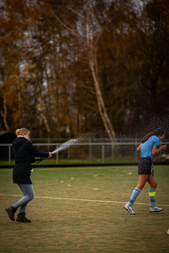 A woman holding a firehose that is spraying water.