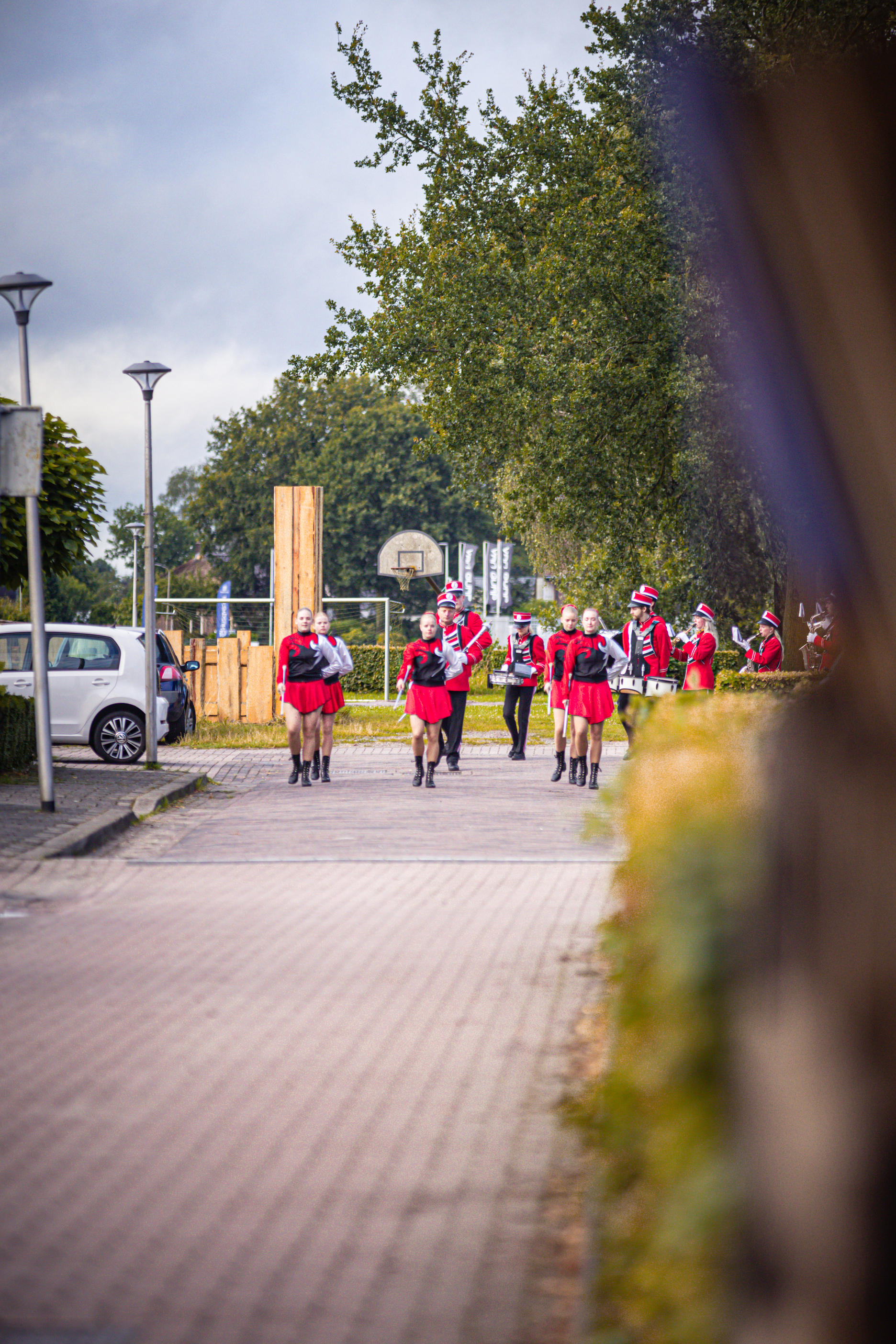 A group of people in red and white walking down a street.