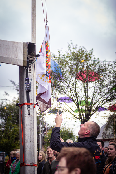 A man holding up a flag at an event called Kermis Boerhaar.