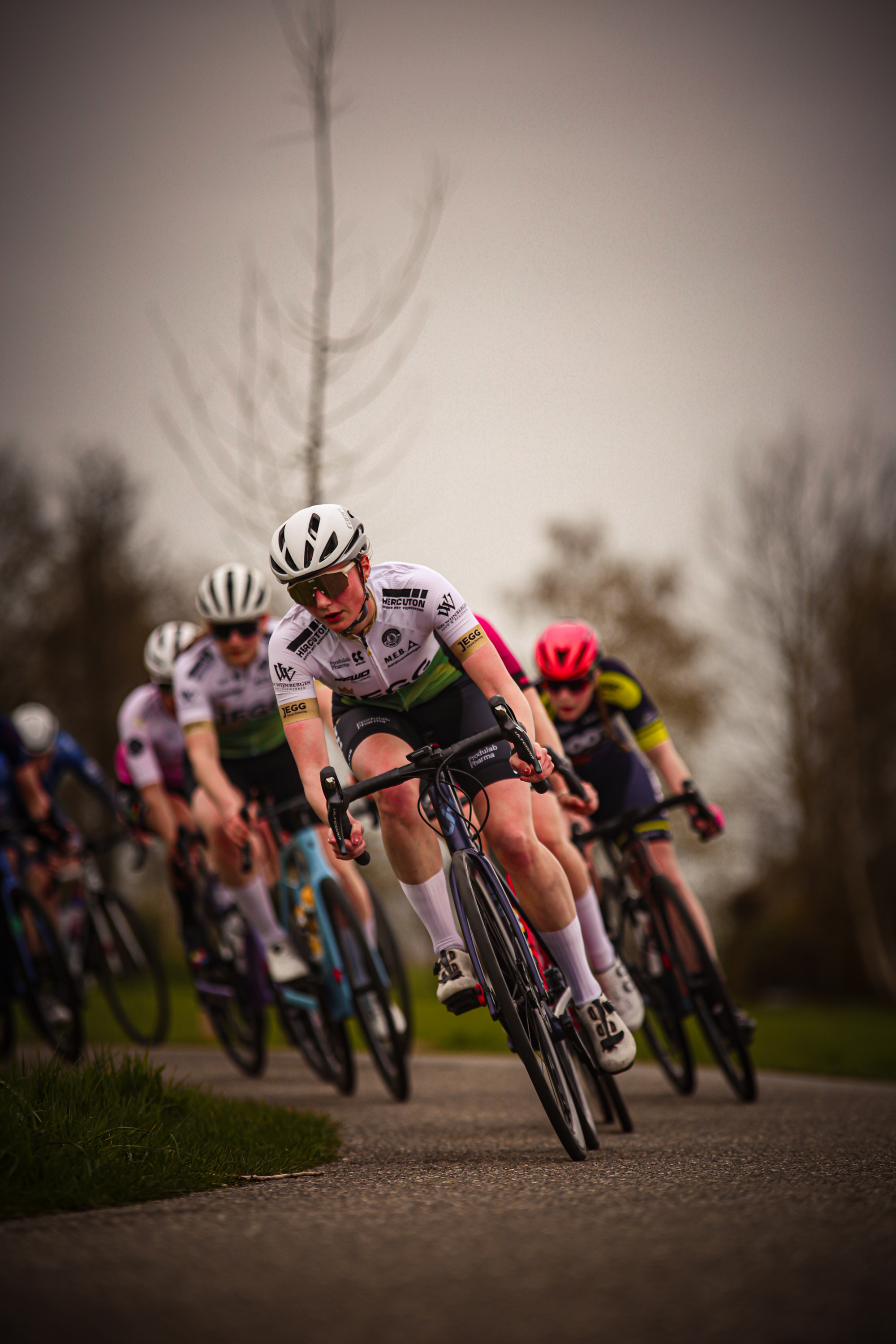 A cyclist named "Jasper" is leading a group of cyclists during the Ronde van de Lichtmis, sponsored by Jumbo.