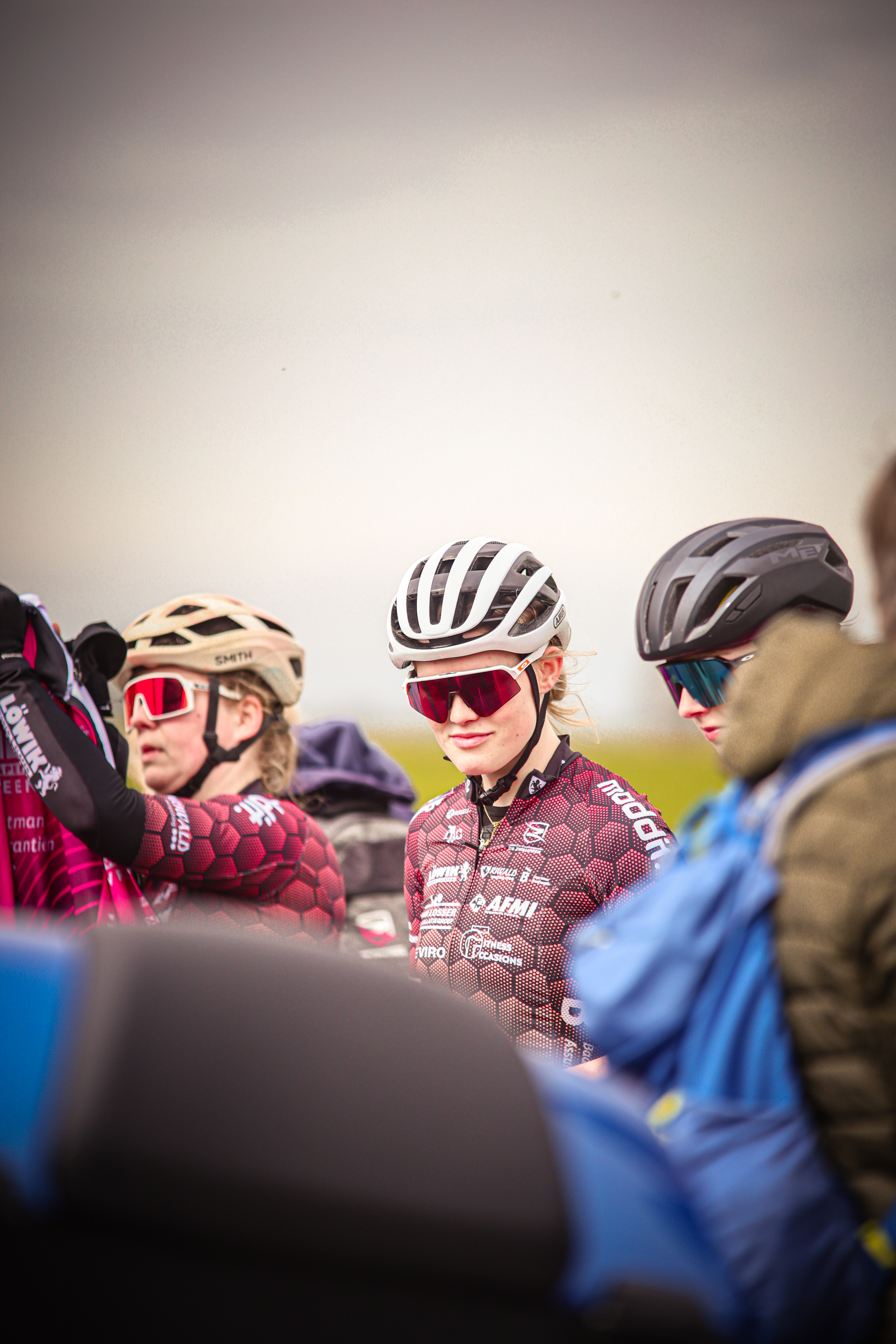 Group of cyclists wearing helmets and brightly colored clothes.