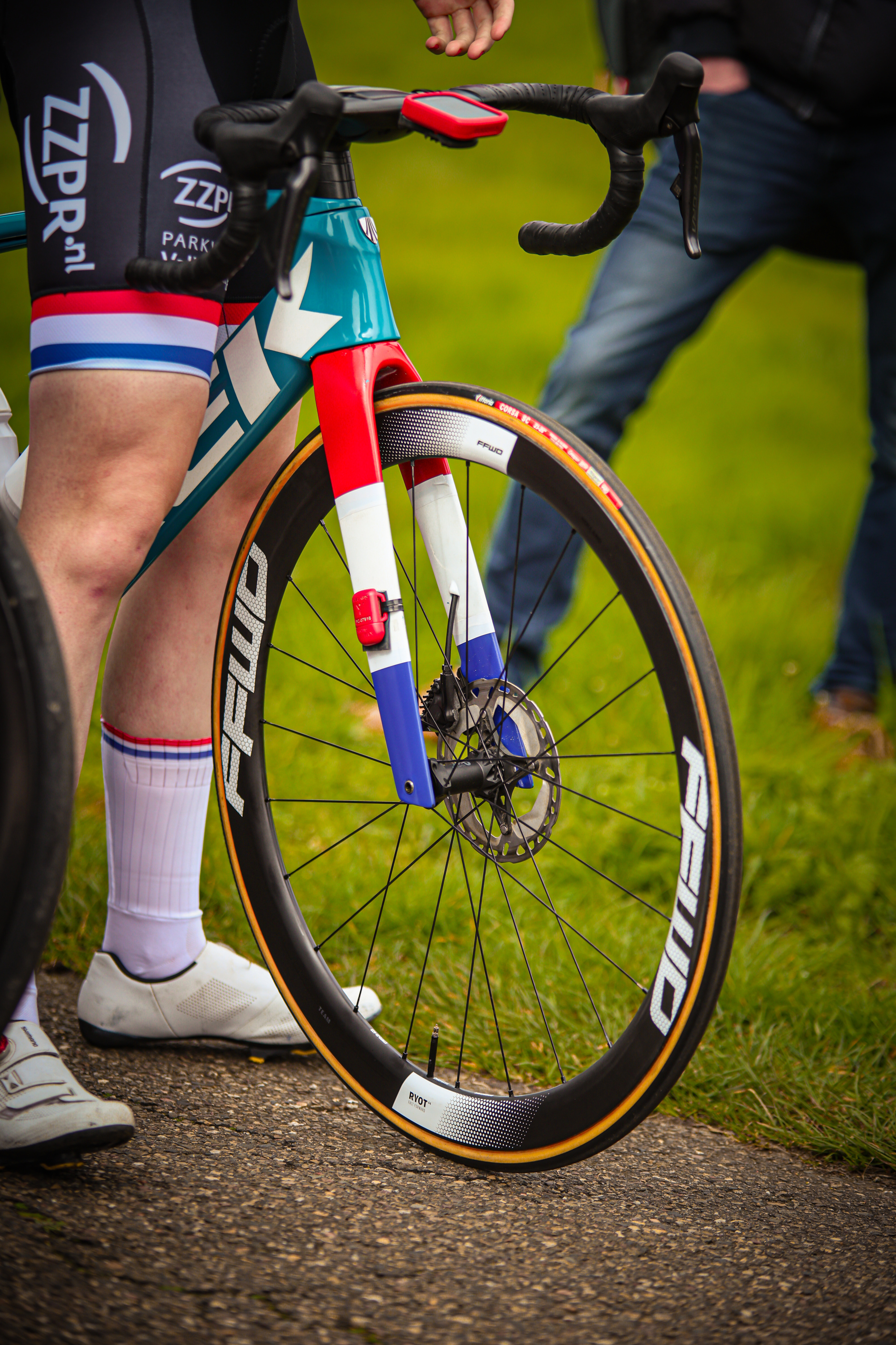 A bicycle rider has a white, blue and red handlebar. The rider is wearing shorts with the brand "ZiBON" written on it.