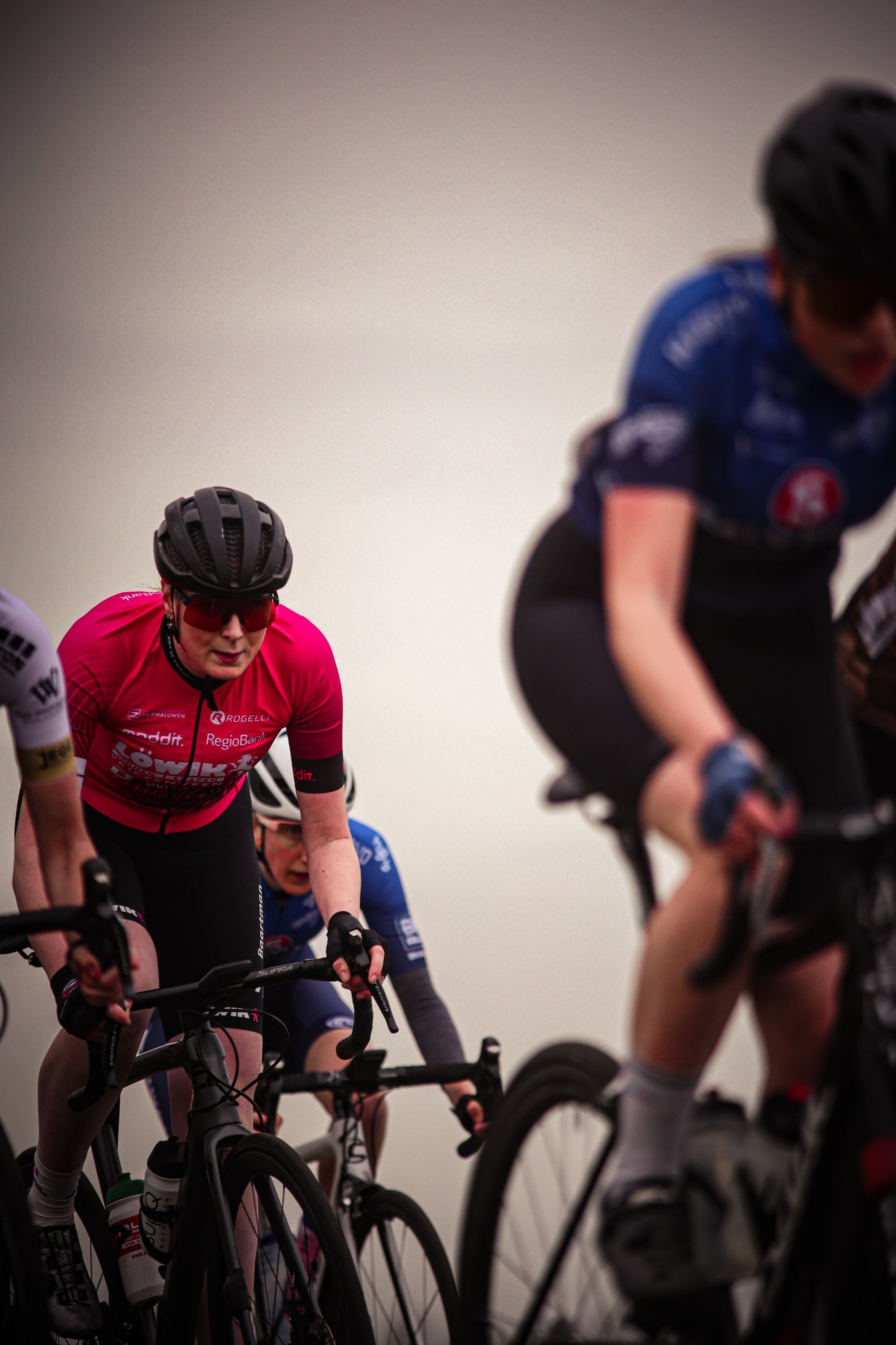 A group of cyclists in motion with a backdrop of a city.