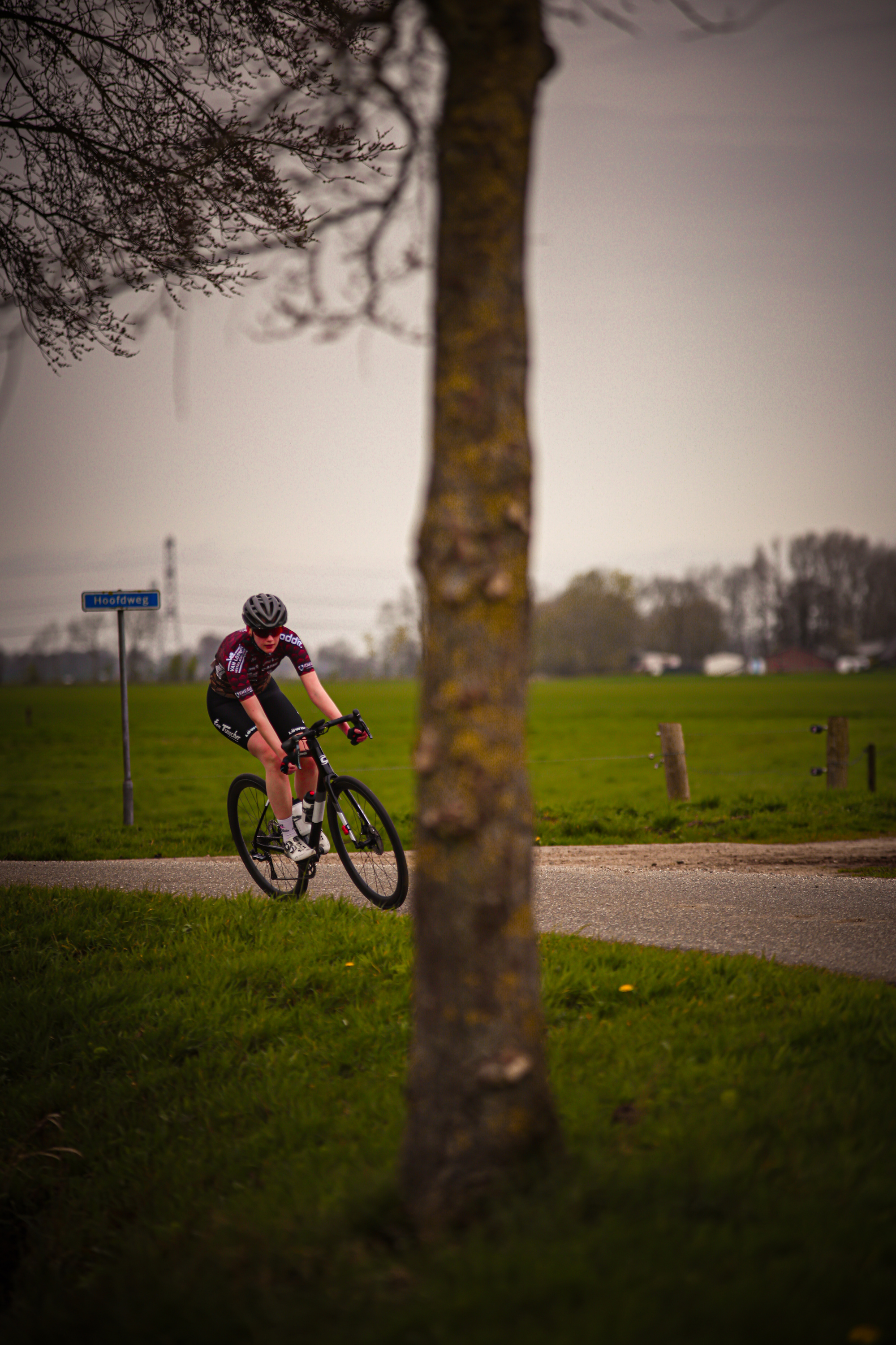 A cyclist wears number 15 and rides down a dirt road.