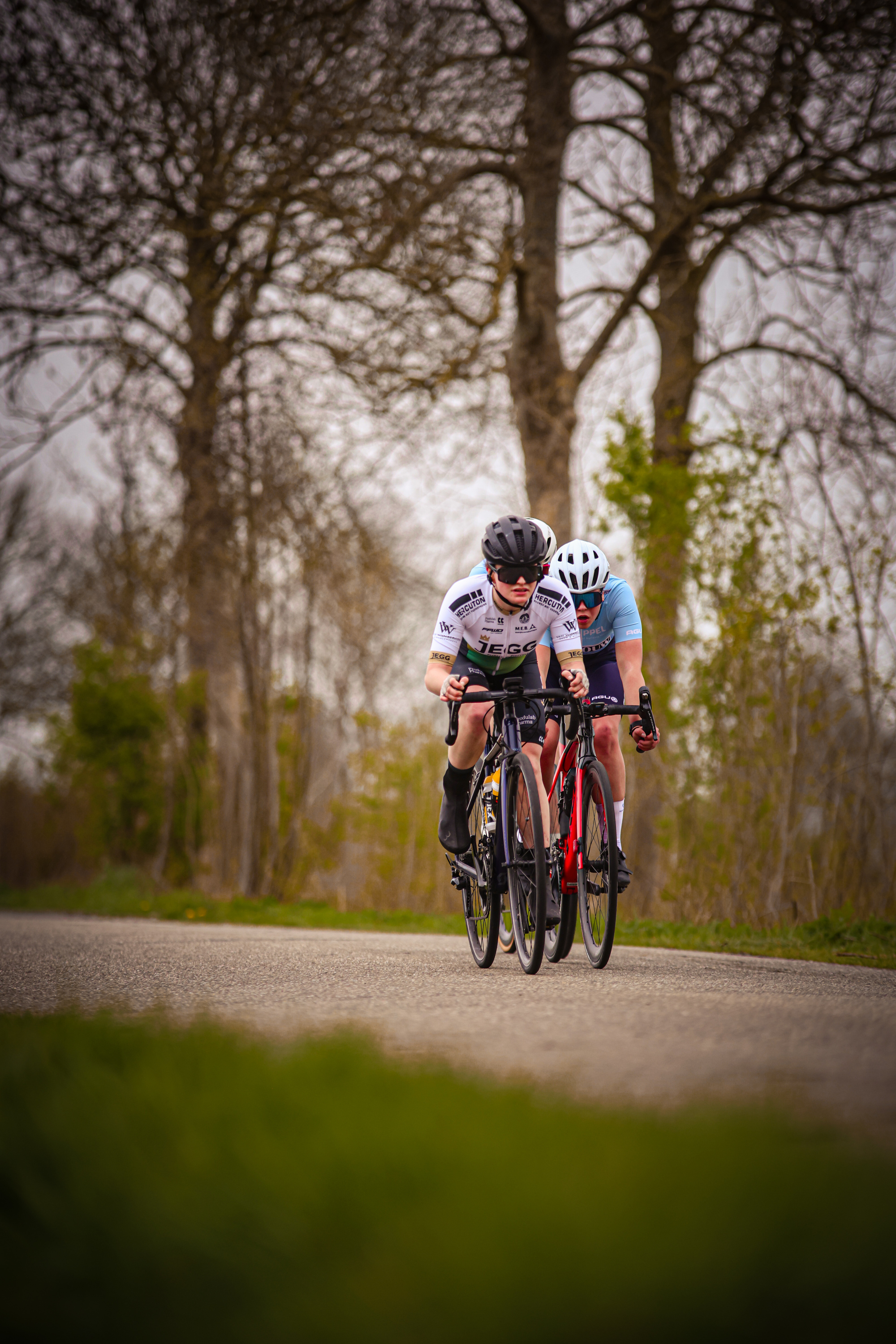 Two men on bikes in the Netherlands are racing during the Ronde van de Lichtmis event.