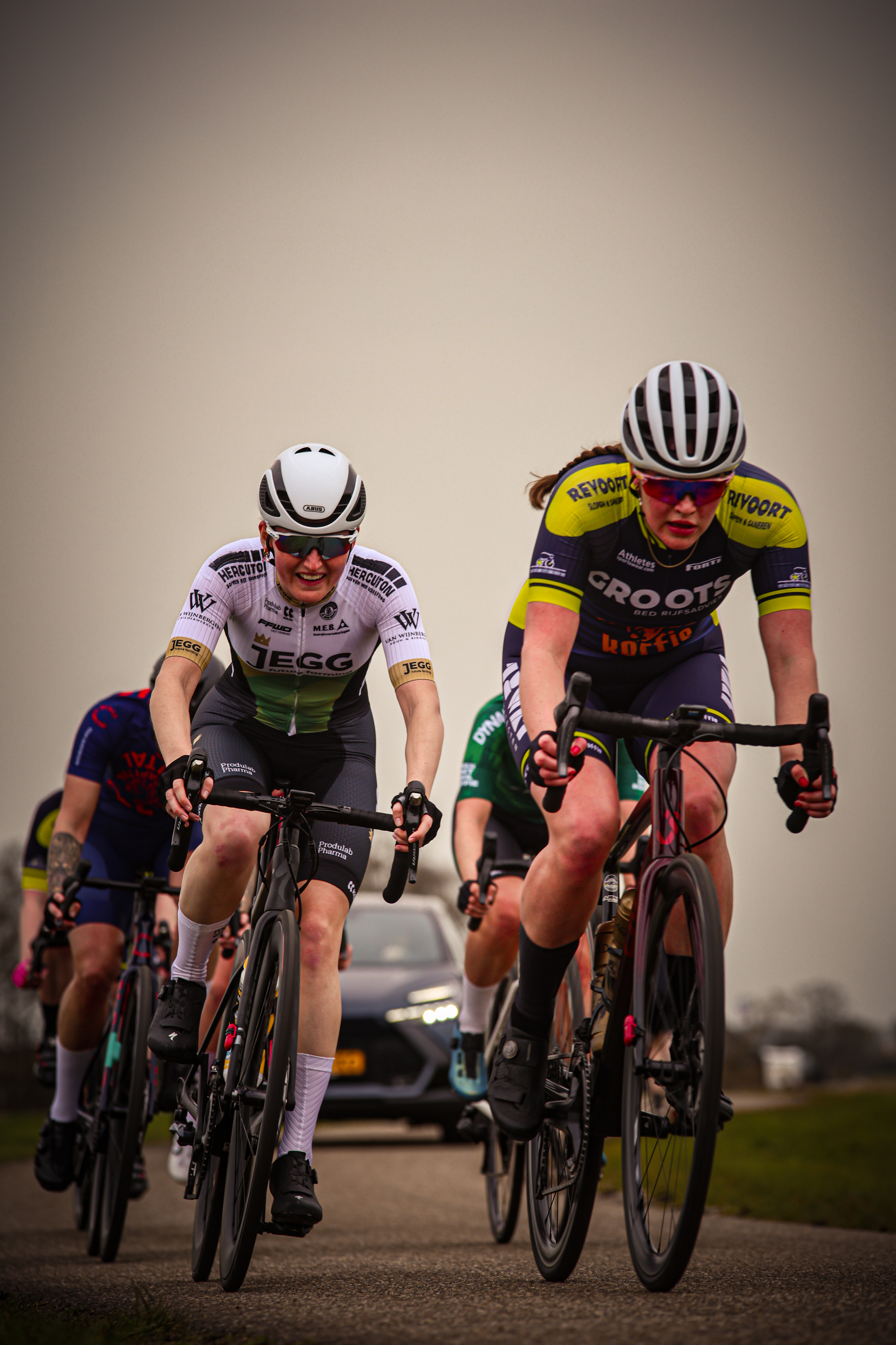 A group of cyclists riding in a line on the road during a race.